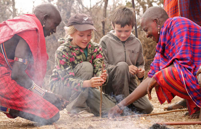 Kids learning to make fire on a bush walk with Masaai - Kenya with kids