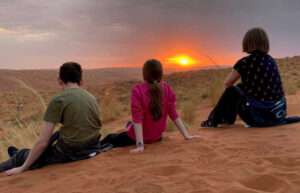 Family enjoying sunset in Namibia on the dunes
