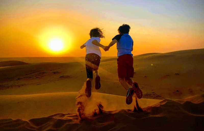 Kids running down dunes in Oman, visit on February half term