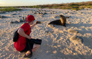 Teenager taking close up photo of seals in Galapagos - Easter family holidays in Ecuador