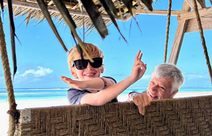 Holidays with grandparents, child with grandad on the beach
