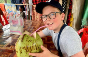 Boy on holiday drinking from a coconut in Cambodia