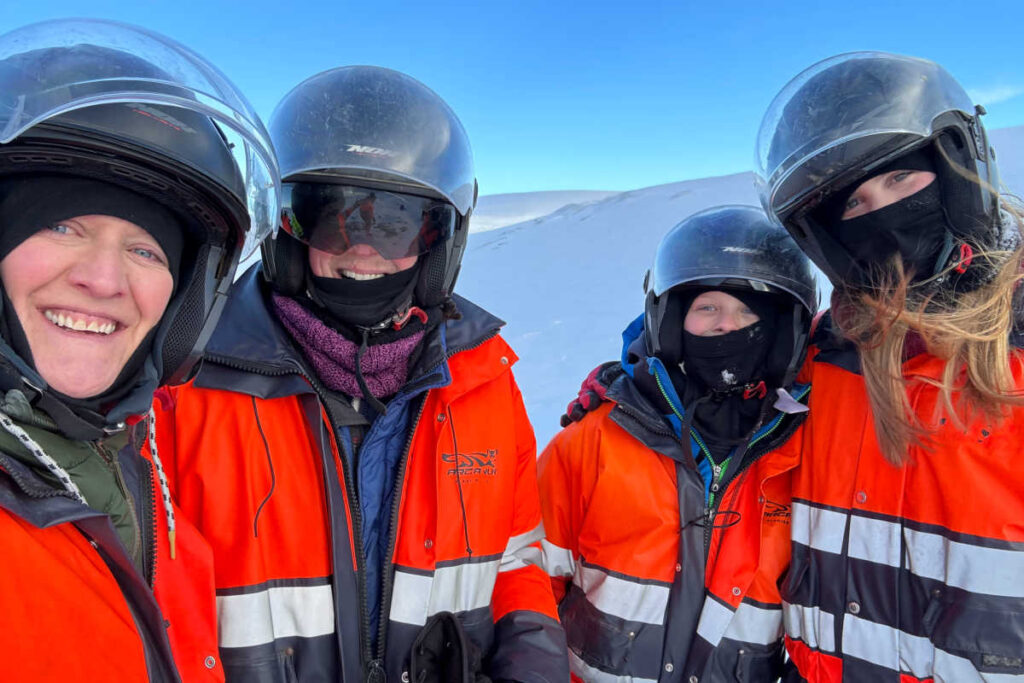 Family snowmobile outing - with red jackets and crash helmets