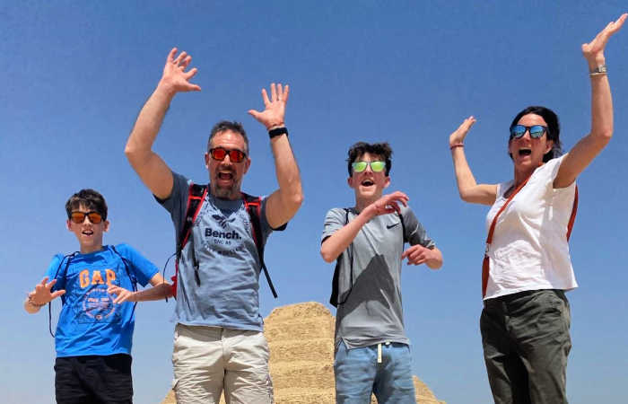 Family jumping with pyramid behind - October half term holiday in Egypt