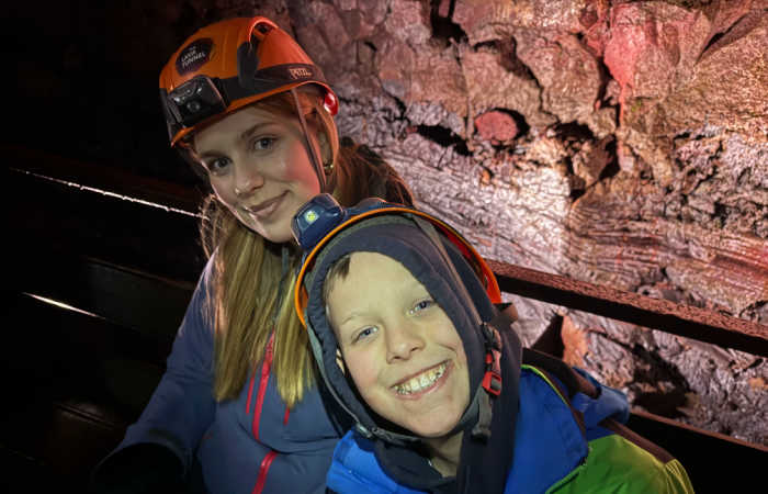 Kids exploring a lava cave in Iceland