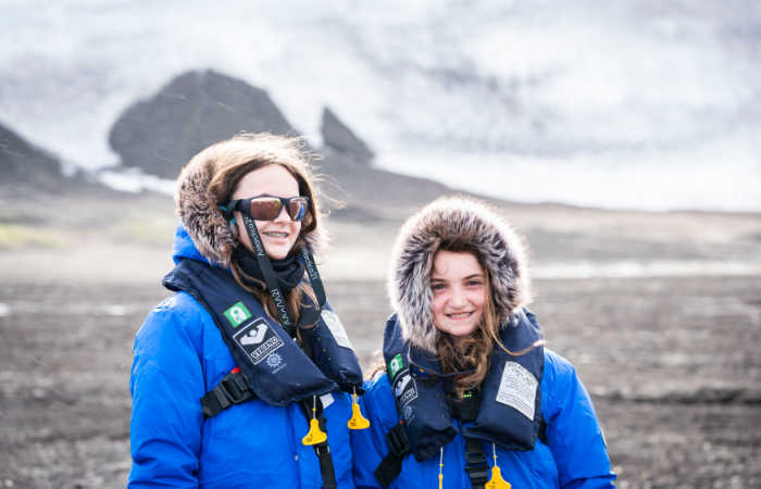 Mother and daughter in warm coats, with life jackets, in Antarctica