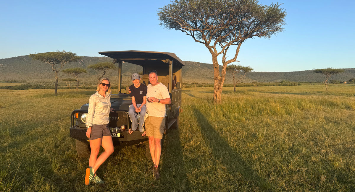 Family beneath an acaia tree in the Masai Mara, a favourite 50th Birthday holiday idea