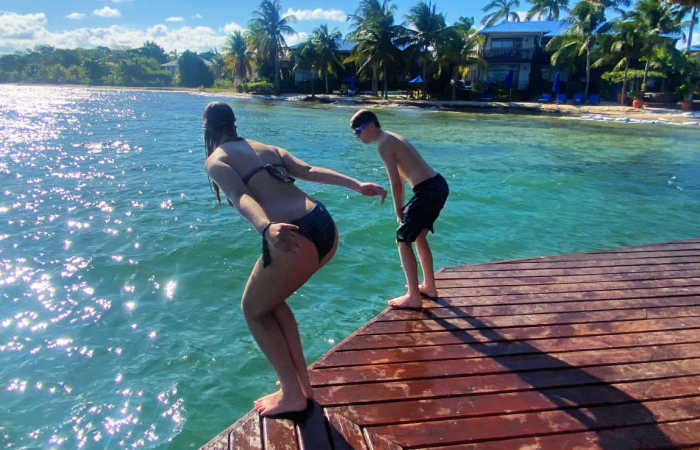 Kids diving from a jetty in Belize, turquoise sea, Latin America family travel guide