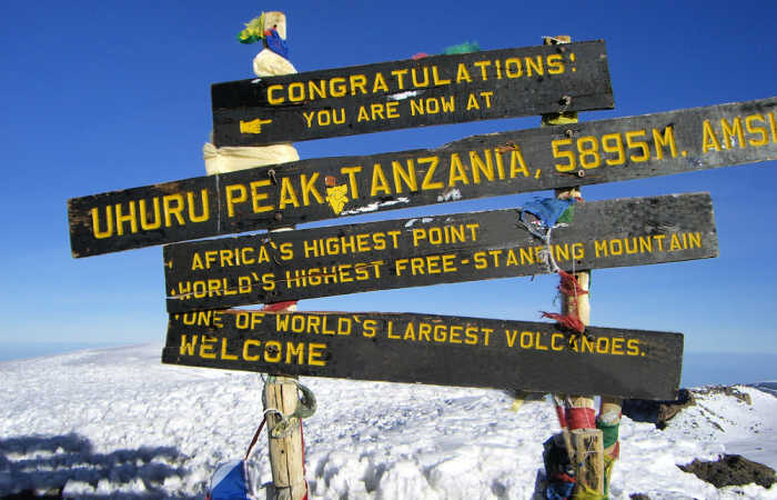 Uhuru Peak summit with sign, sky is blie