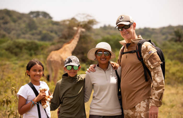 Family walking with giraffe in Arusha, Tanzania safari and beach itinerary