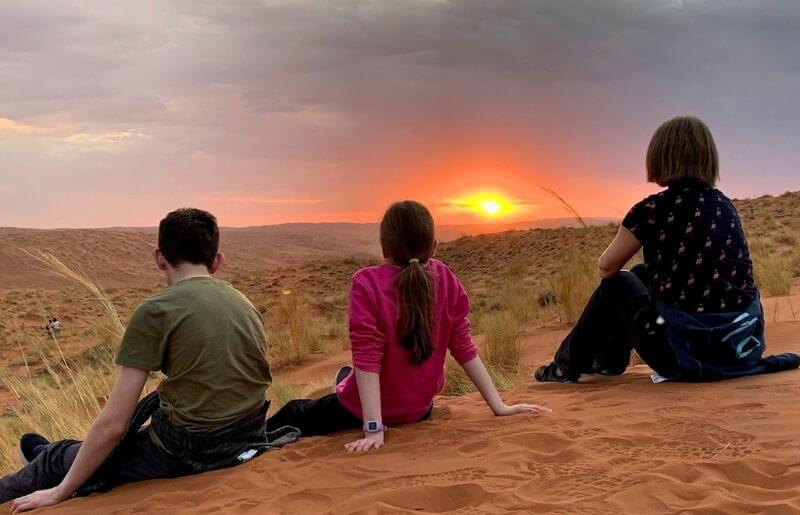 Family enjoying sunset in Namibia on the dunes