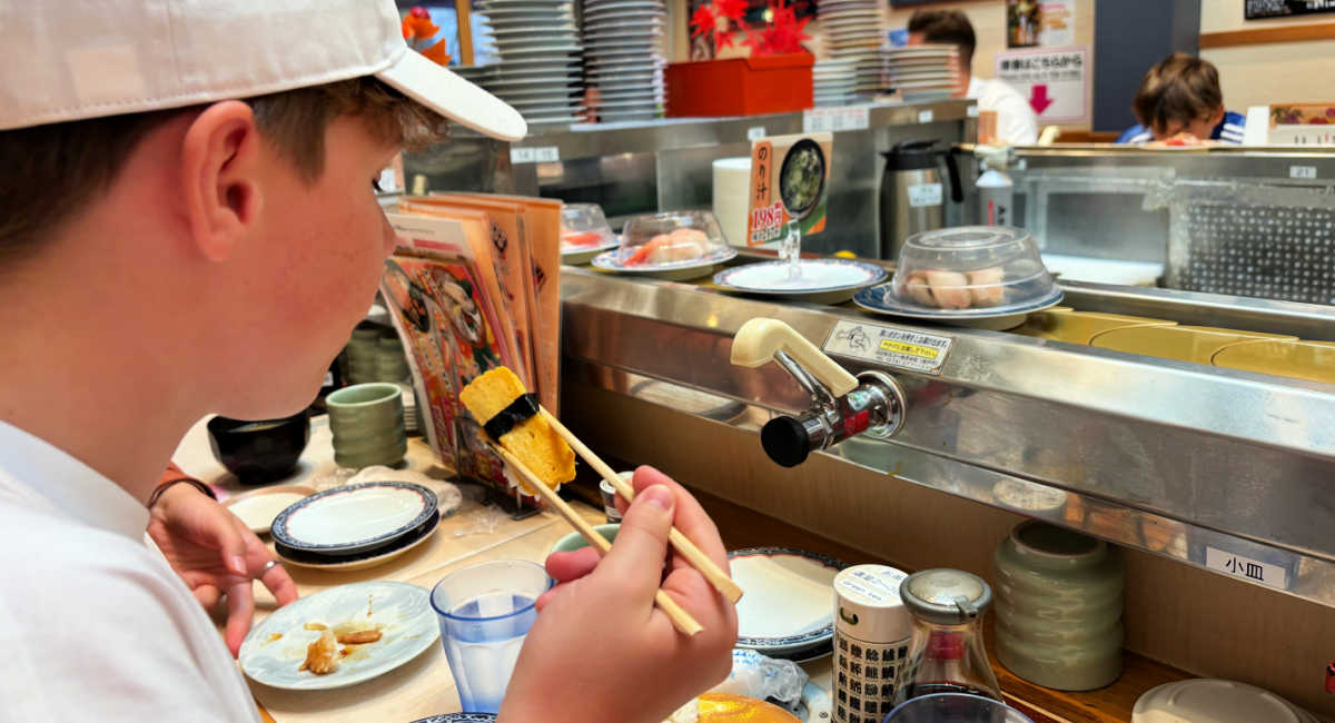 Pre-teen on holiday in Japan, eating in a sushi bar 21 things to do in Japan with kids
