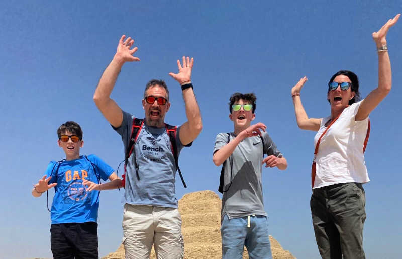 Family jumping with pyramid behind - October half term holiday in Egypt