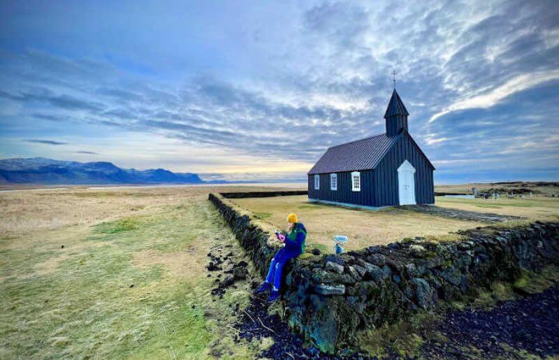 Iceland teenager by traditional wooden church