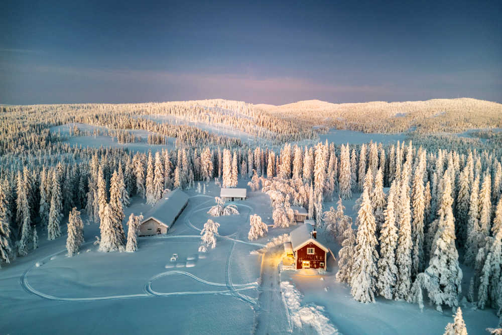 Aerial view of lodge in Swedish Lapland, surrounded by snow-covered pines