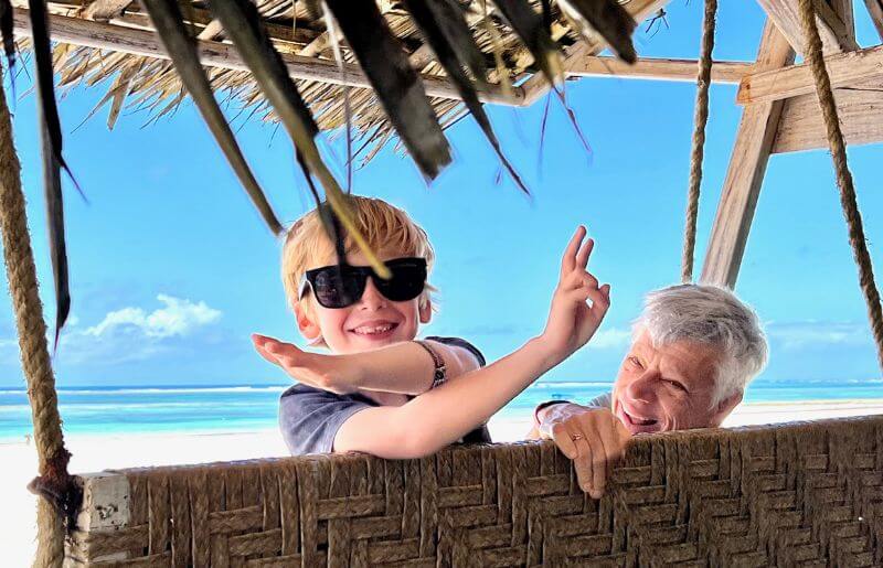 Holidays with grandparents, child with grandad on the beach
