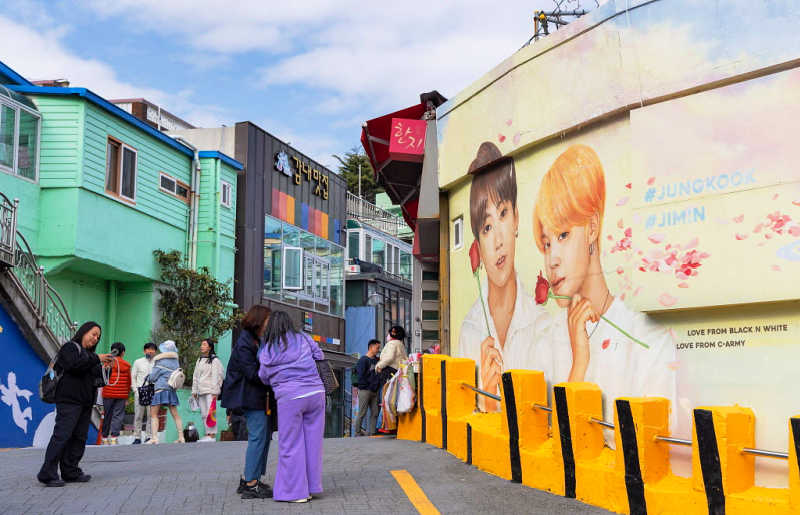See the mural of K-pop singers at Gamcheon Culture Village, Busan, on a South Korea family holiday