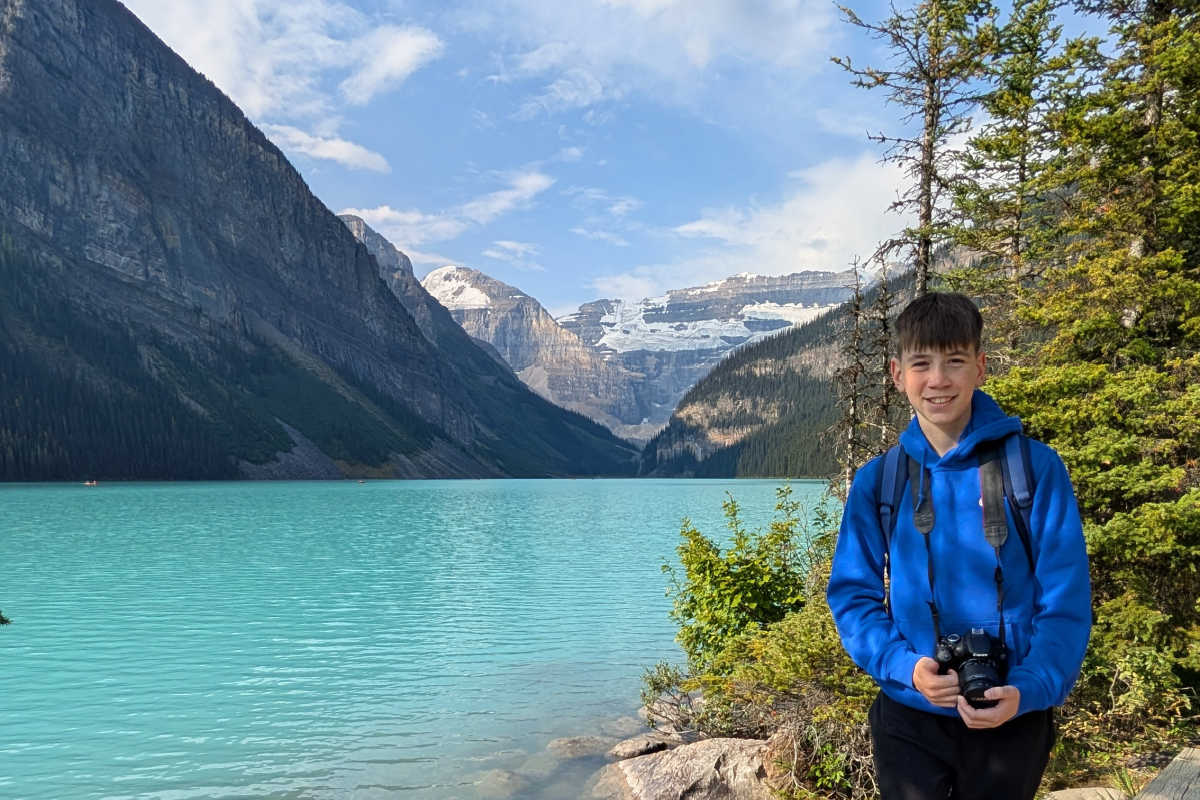 Lake Louise, Canada, with teenager taking scenic photos on a family trip