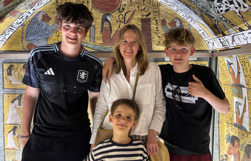 Family with two teenagers and a younger child on holiday in Egypt, arranged by Stubborn Mule Travel, enjoying a guided tour of an ancient Egyptian tomb, in the Valley of the Kings