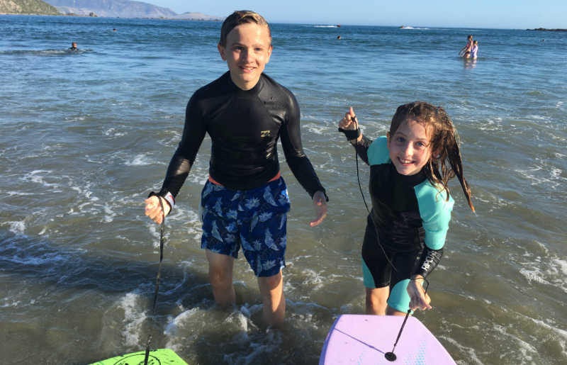 Kids on boogie-boards in New Zealand, Christmas family holiday