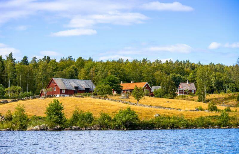 Traditional red Swedish houses above the lake - family holidays in Sweden