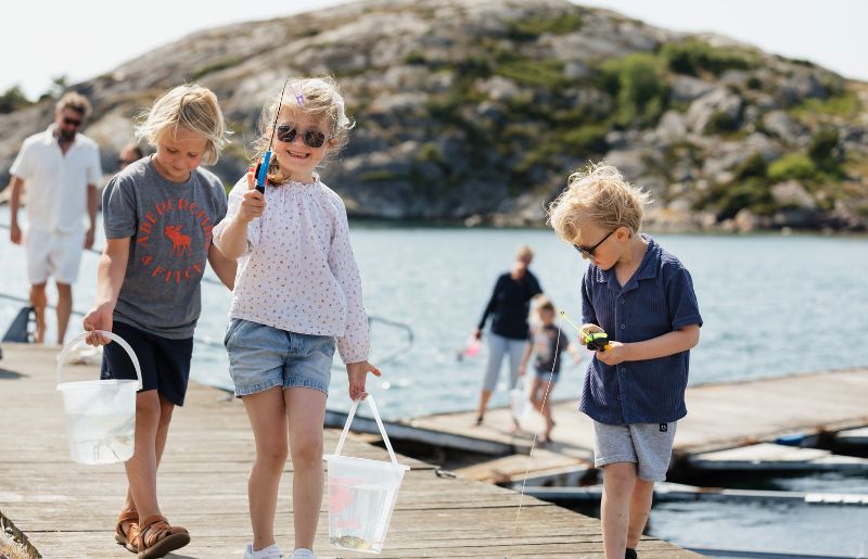 Kids crab fishing on the pier on a Swedish family holiday