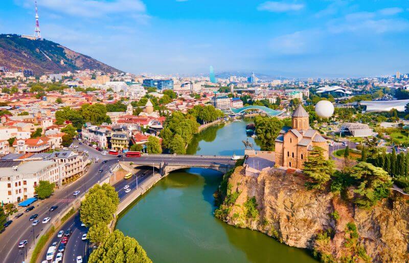 Aerial view over Tbilisi, with the bridge over the river, the old town and the church - family-friendly holidays to Georgia