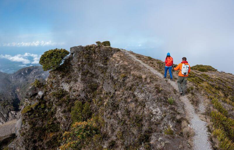 Two people hiking over Volcan Baru and into the clouds - family-friendly holidays to Panama