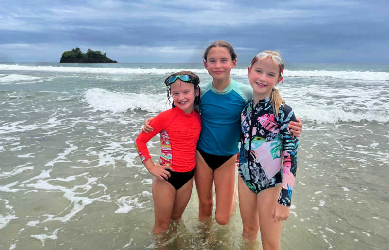Family standing in the sea for a photograph, on lovely Costa Rica beach, Central America holidays suitable for all ages