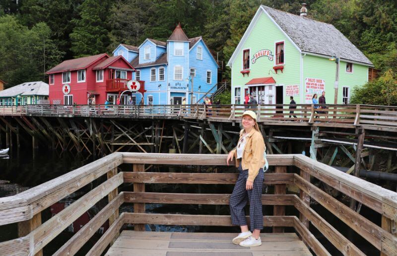 Teenager poses in front of the colourful stilted buildings in Ketchikan, Alaska