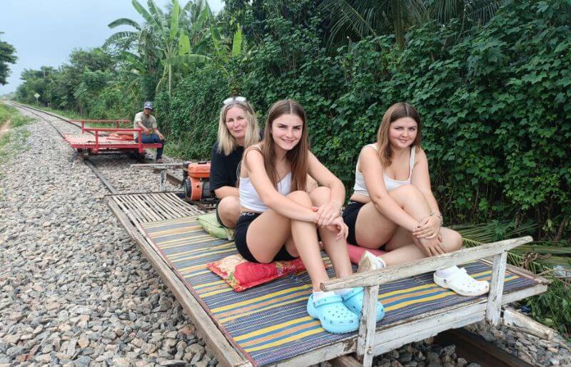 Mum and teenage daughters on a bamboo train in Cambodia