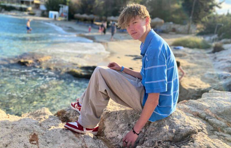 Teenager on the beach in Crete, on a half term holiday when the temperature is cooler - coolcations.
