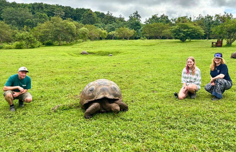 A family pose next to a giant tortoise on the Galapagos Islands
