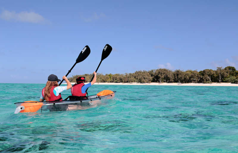 Teenagers kayaking on Australia's Great Barrier Reef